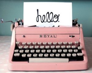 Pink Royal typewriter with paper that says 'hello'